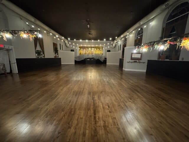The finished hall floor under string lights, dark and even from end to end