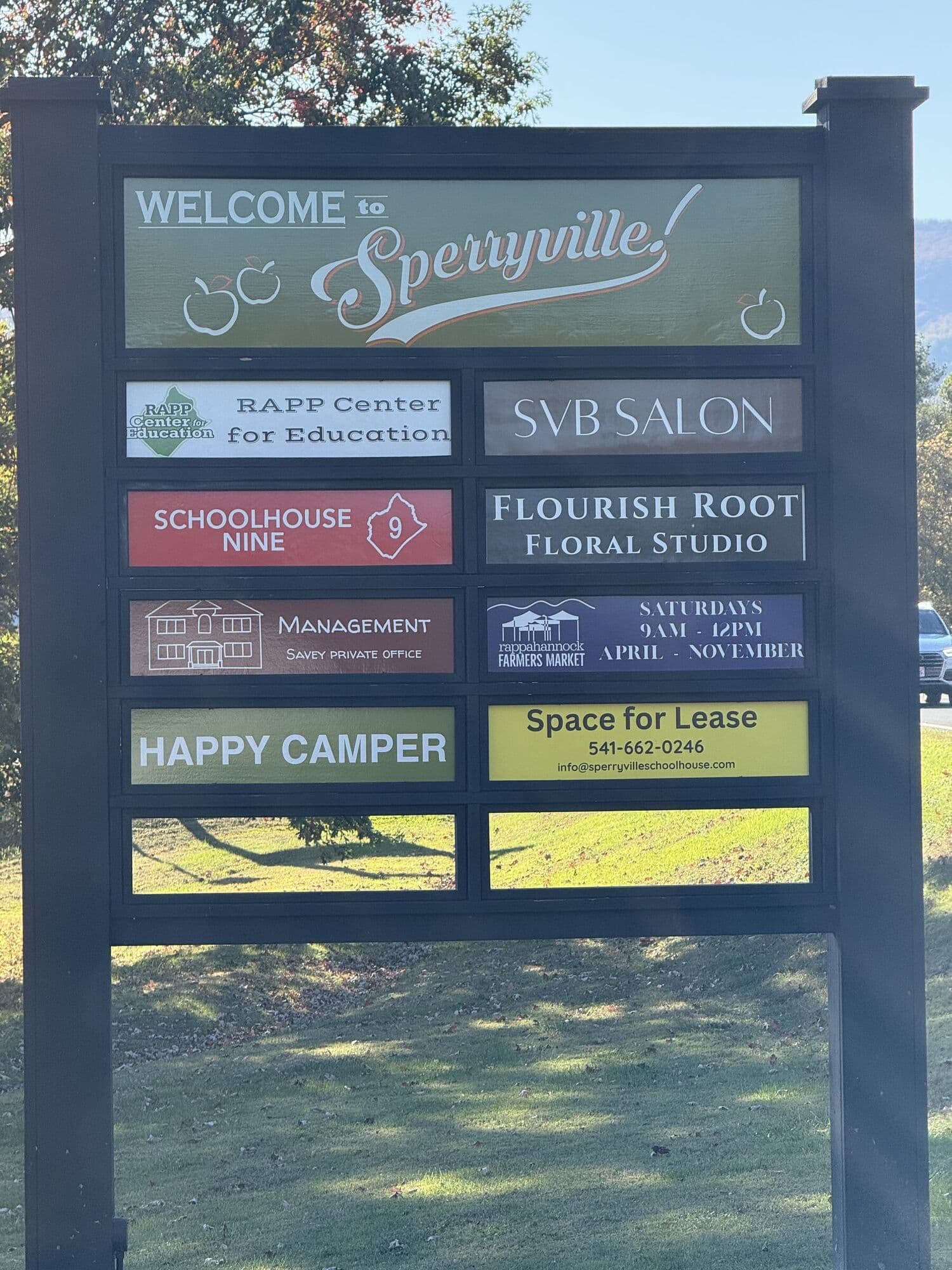 A roadside sign display built for the Sperryville School House, holding painted panels for the businesses inside