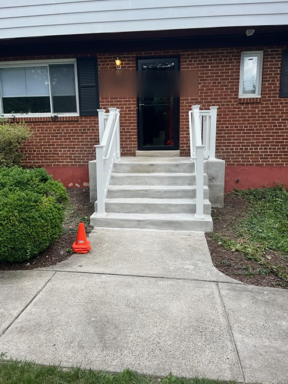 After: the finished steps straight on, white rail either side of the walk